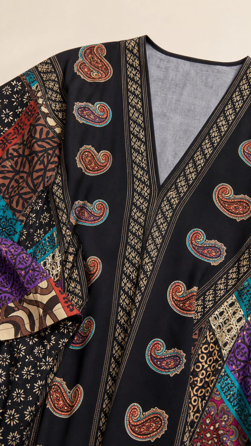 Close-up detail of V-neckline and paisley pattern on black kaftan dress