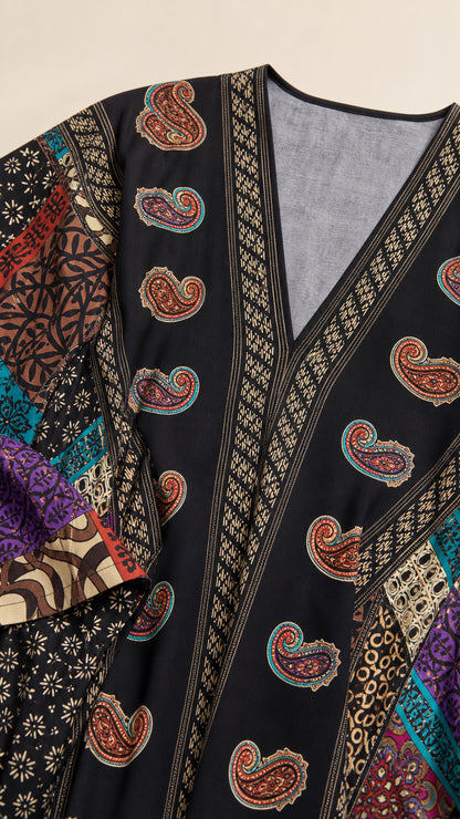 Close-up detail of V-neckline and paisley pattern on black kaftan dress